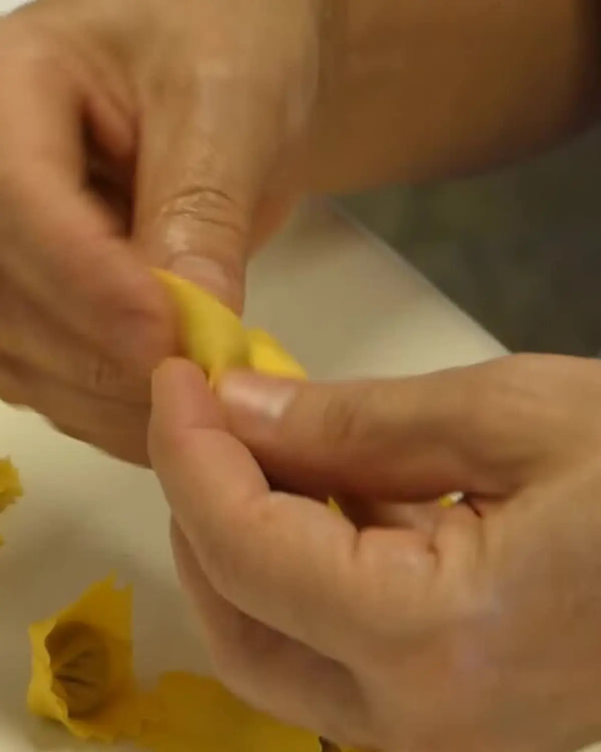 Le mani che chiudono i tortellini uno per uno